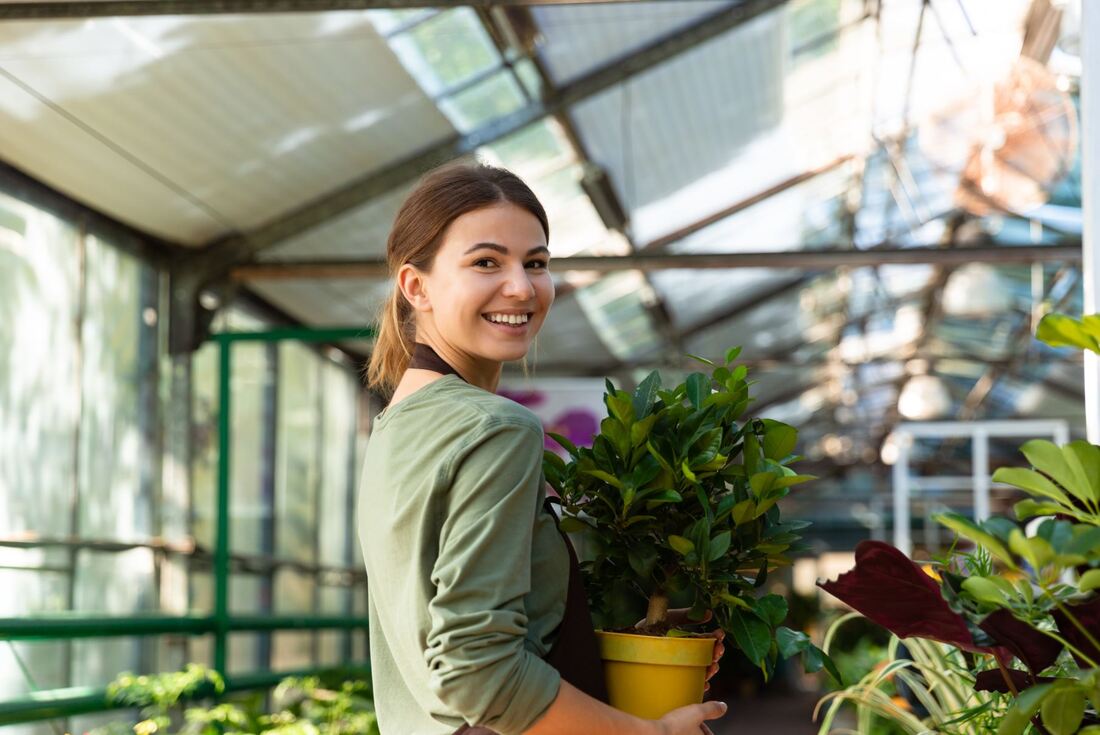 Woman holding a potted plant and smiling