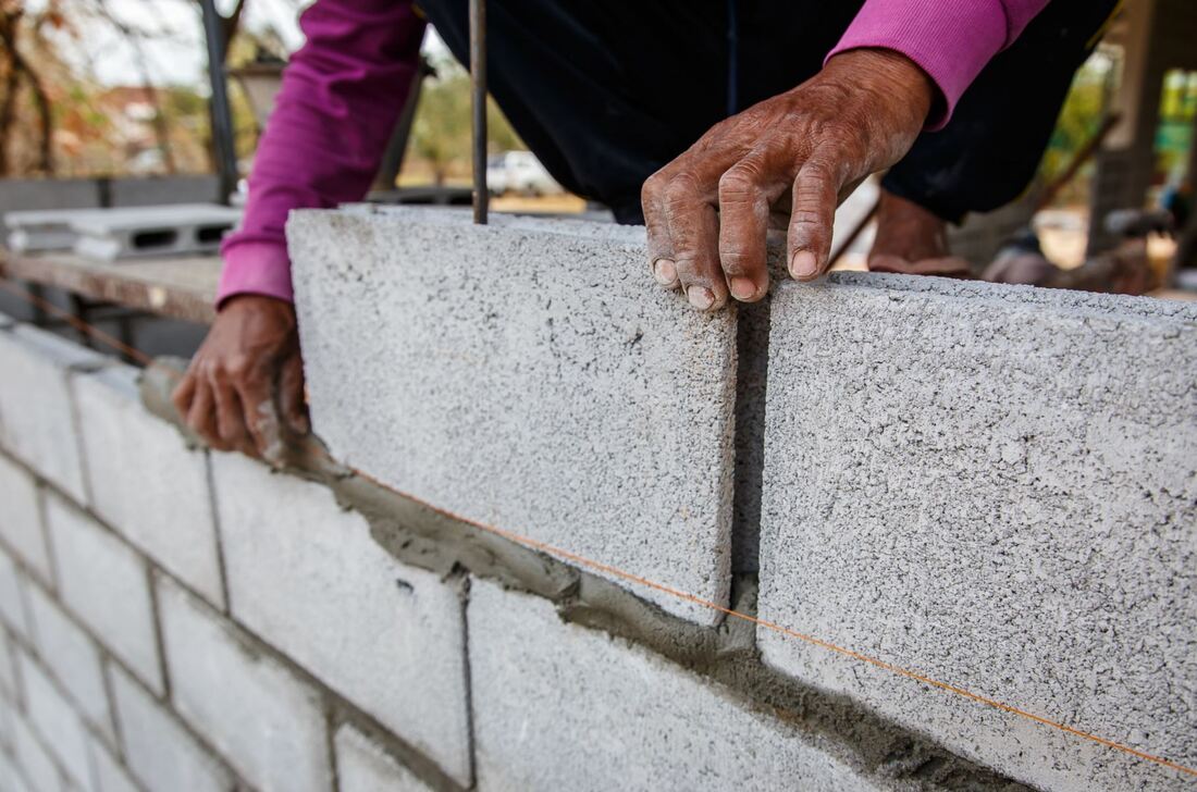 close up of a worker installing masonry bricks on a construction site
