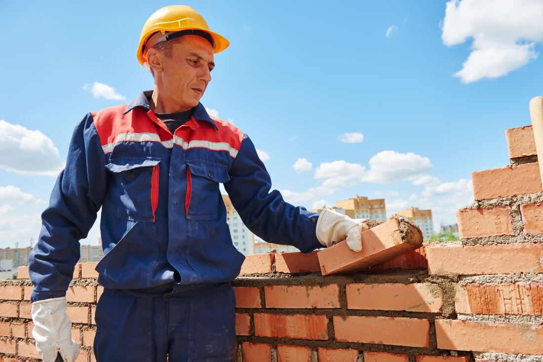 Bricklayer placing brick on a wall
