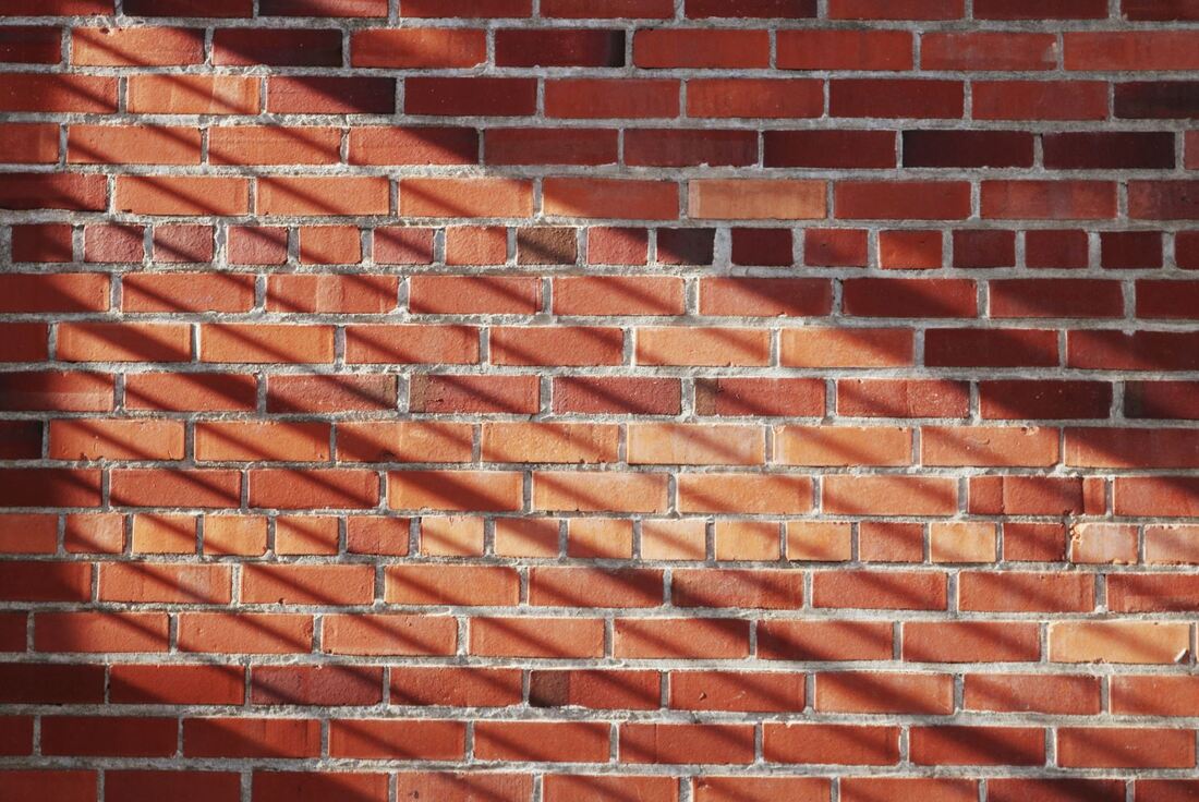 Photo of a brickwall with some lined shadows running through it